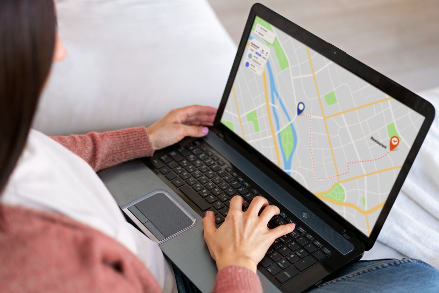 Keene Marketing Agency Person using a laptop with a map application displaying a route between two points on the screen, illustrating an essential step in user journey mapping.