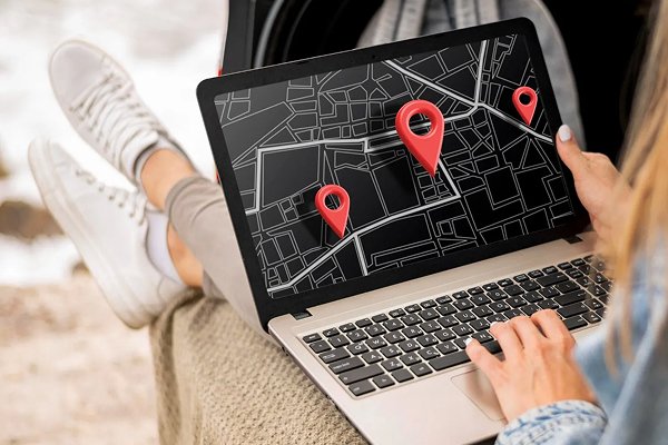 New Hampshire A person using a laptop with a digital map and red location pins displayed on the screen, illustrating Local SEO strategies for multilocation retail by Freitag Marketing. Marketing Agency