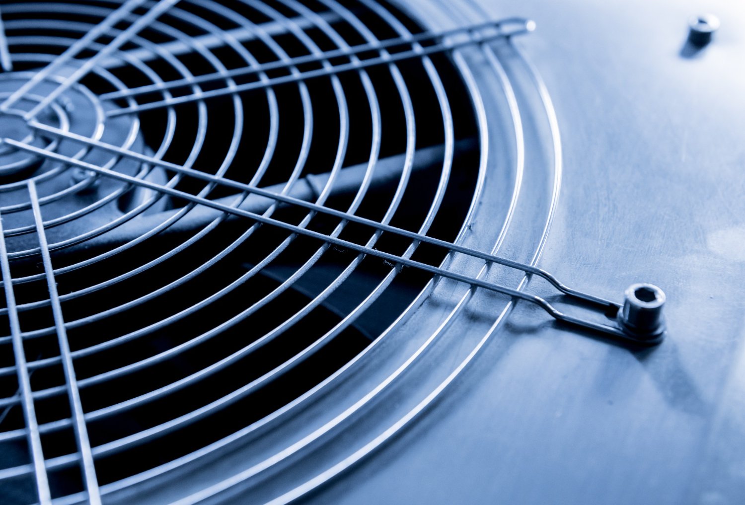 New Hampshire Close-up of a metallic fan grill and protective cover, likely part of an industrial or HVAC cooling unit, shown in blue-tinted lighting—ideal imagery for New Hampshire HVAC companies developing a marketing plan. Marketing Agency