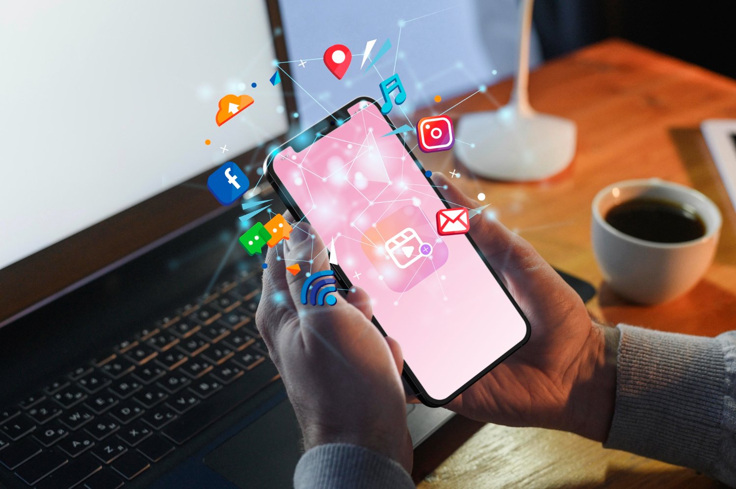 New Hampshire Person holding a smartphone with digital social media and app icons floating above the screen, illustrating how to operationalize social media strategies or follow a 2025 social media trends playbook, in front of a laptop and coffee on a desk. Marketing Agency