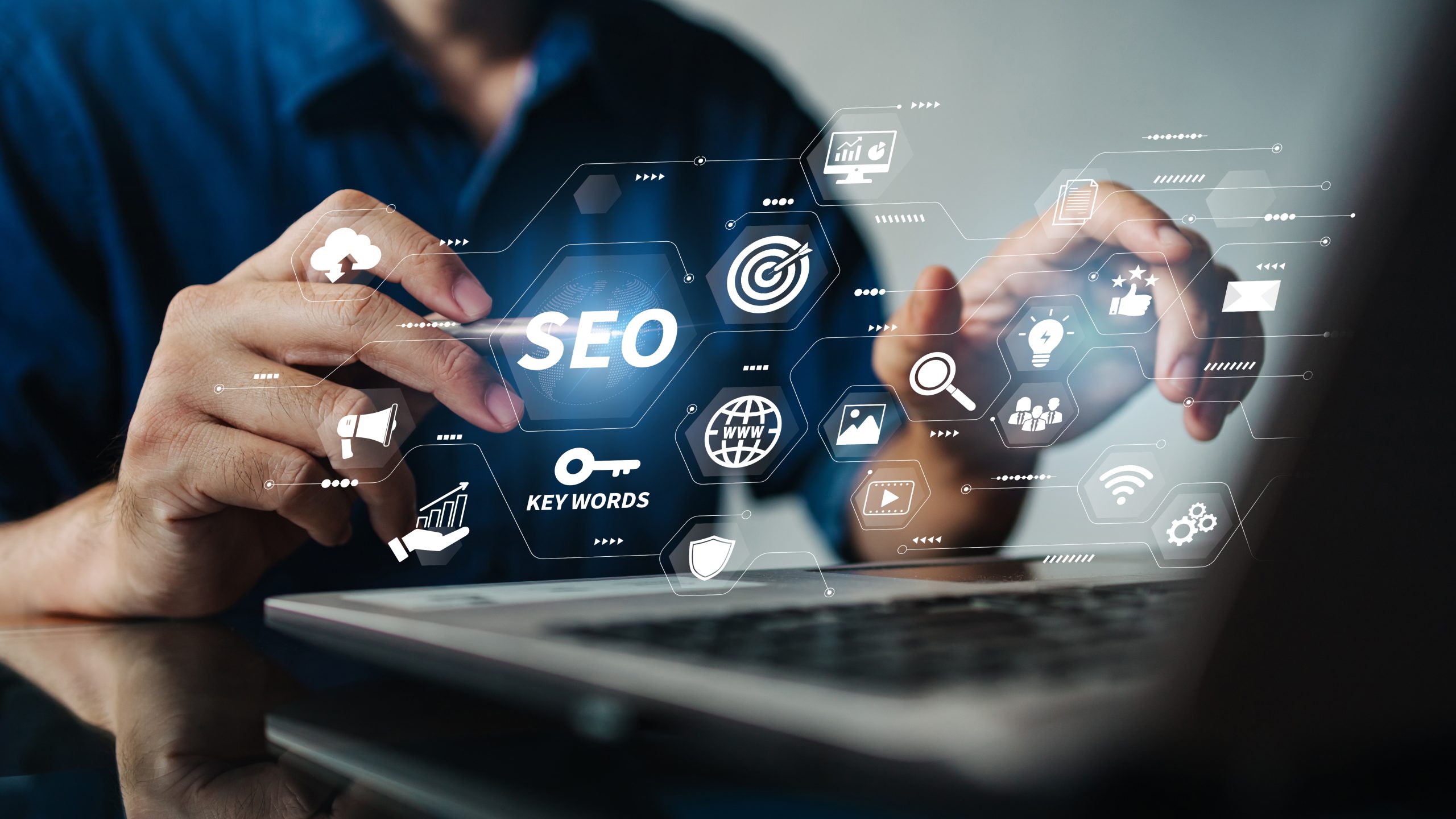 New Hampshire Person working on a laptop with virtual graphics displaying SEO-related icons and terms such as "keywords," "ranking," and "content. Marketing Agency