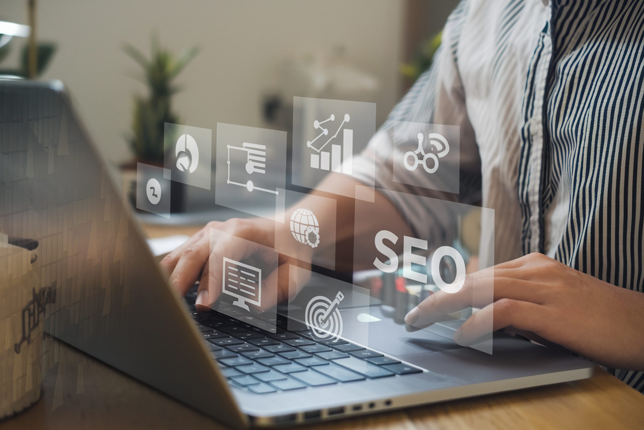 New Hampshire Person typing on a laptop with floating digital icons related to SEO, analytics, and online marketing concepts, showcasing the expertise of the best partner SEO agency. Marketing Agency