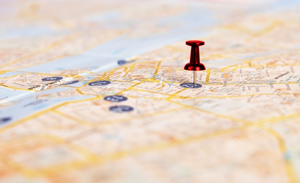 New Hampshire A close-up of a paper map with a red pushpin marking a specific location in New Hampshire, highlighting the importance of local search performance among various streets and landmarks. Marketing Agency