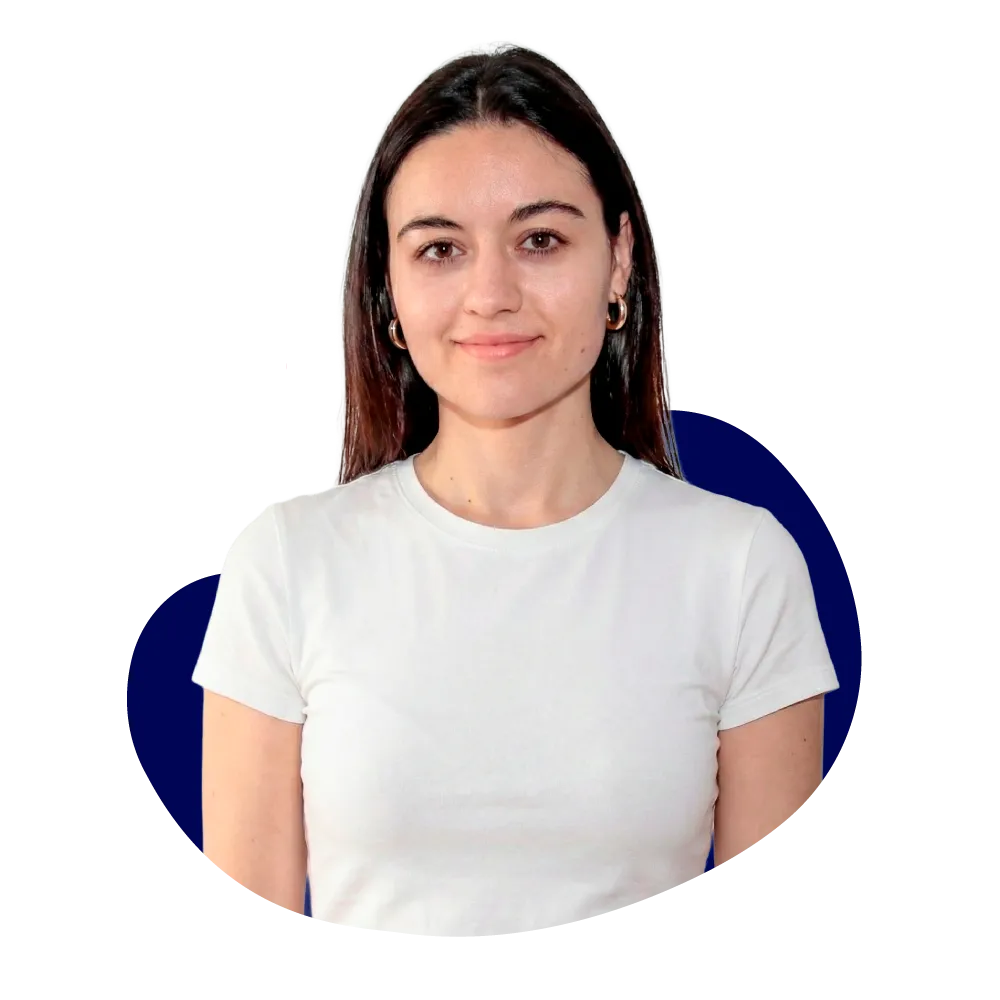 New Hampshire A woman with straight brown hair wearing a plain white t-shirt stands in front of a black background with a navy blue abstract shape. Marketing Agency