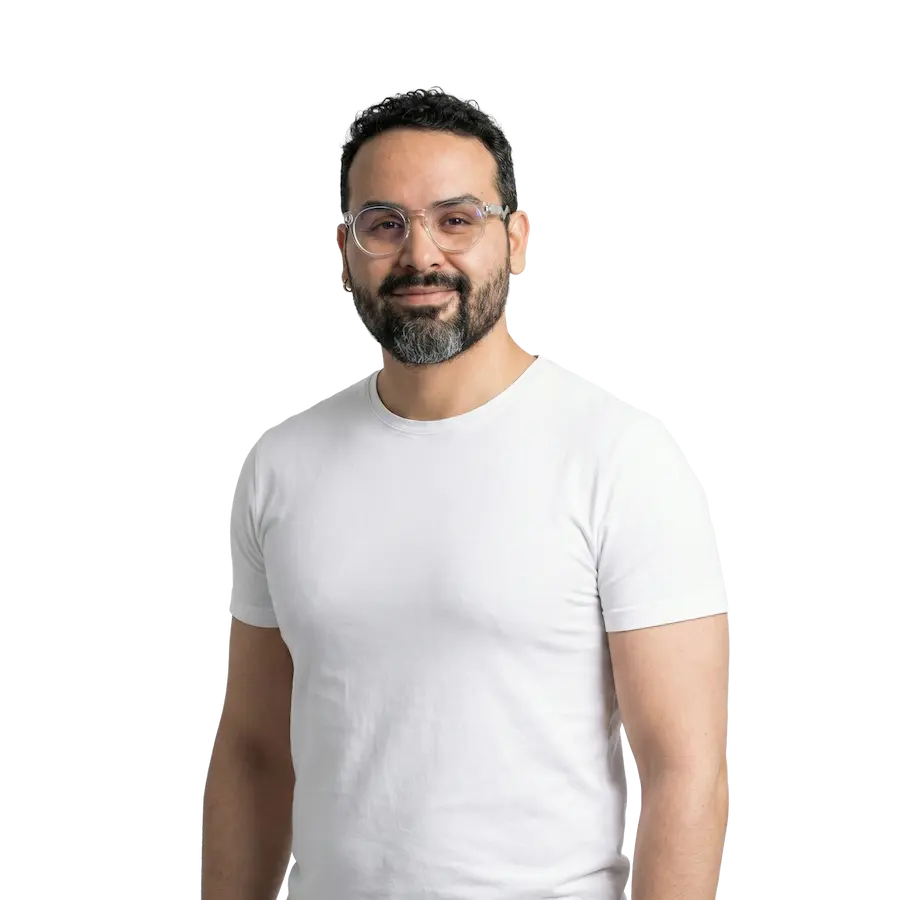 New Hampshire A man with dark hair, beard, and glasses is wearing a white t-shirt and standing against a plain background, facing the camera and smiling slightly. Marketing Agency